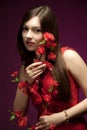 Young woman model in red dress standing and holding branch with flowers Royalty Free Stock Photo