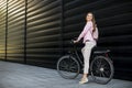 Young woman with modern city electric e-bike as clean sustainable urban transportation