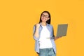 Young woman with modern laptop on yellow