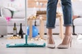 Young woman with mop cleaning messy room after party Royalty Free Stock Photo