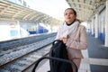 Young woman, a mother with baby carriage, looking into distance while waiting for train on the railway station platform Royalty Free Stock Photo