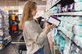 Young woman mother chooses diapers at supermarket in shop mall. Royalty Free Stock Photo