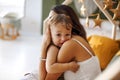 Young woman mother expressing love to little baby, sitting on bed with sleeping son Royalty Free Stock Photo