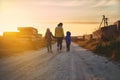 Young woman, mother with her children walking along a sandy country steppe road in the light of a beautiful sunset Royalty Free Stock Photo