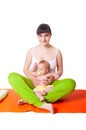 Young woman mother practicing yoga with baby