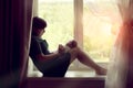 Young woman mother sitting at the window with a newborn baby Royalty Free Stock Photo