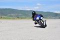 Young woman motorcyclist speeding on tarmac racetrack