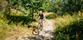 Young woman mountain Bike cyclist riding track in forest at sunn