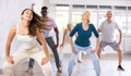 Young woman moves freely and dance hip-hop with unfastened hair in fitness studio