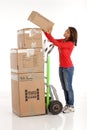 Young woman moving boxes with with a hand truck or dolly.
