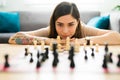 Young woman moving a chess piece on the coffee table Royalty Free Stock Photo
