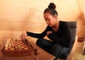 Young woman moving with chessman in chess Royalty Free Stock Photo
