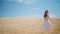 Young woman moving spikelets meadow back view. Carefree girl running wheat field Royalty Free Stock Photo