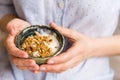 Young woman with muesli bowl. Breakfast cereals with nuts, pumpkin seeds, oats and Yogurt in bowl. Hands holding granola Royalty Free Stock Photo