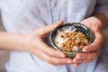 Young woman with muesli bowl. Breakfast cereals with nuts, pumpkin seeds, oats and Yogurt in bowl Royalty Free Stock Photo