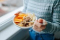 Young woman with muesli bowl, girl eating breakfast cereals nuts, pumpkin, oats and apple in bowl. Royalty Free Stock Photo