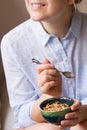 Young woman with muesli bowl. Girl eating breakfast cereals with nuts, pumpkin seeds, oats and yogurt in bowl. Girl holding Royalty Free Stock Photo