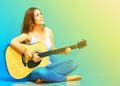 Young woman musician with guitar sitting on a floo Royalty Free Stock Photo