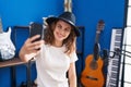 Young woman musician making selfie by smartphone at music studio