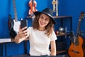 Young woman musician making selfie by smartphone at music studio