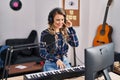 Young woman musician playing piano keyboard at music studio Royalty Free Stock Photo