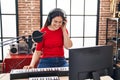 Young woman musician playing piano keyboard at music studio Royalty Free Stock Photo