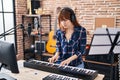 Young woman musician playing piano keyboard at music studio Royalty Free Stock Photo