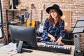 Young woman musician playing piano keyboard at music studio Royalty Free Stock Photo