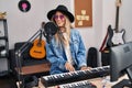 Young woman musician singing song playing piano keyboard at music studio Royalty Free Stock Photo