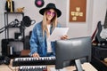 Young woman musician smiling confident playing piano keyboard at music studio Royalty Free Stock Photo