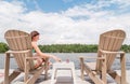Young woman on a Muskoka chair with a glass of champagne.