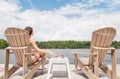 Young woman on a Muskoka chair with a glass of champagne.