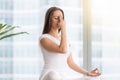 Young woman in nadi shodhana pranayama against floor window Royalty Free Stock Photo