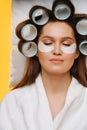 Young woman napping on pillow with hair in rollers and patches under eyes Royalty Free Stock Photo