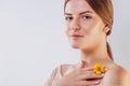 Young woman with natural makeup and smooth skin holding a flower. Organic cosmetics concept Royalty Free Stock Photo