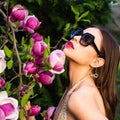 Young woman near blossom park. Spring girl. Woman on spring blooming tree. Beautiful young woman in summer style outfit Royalty Free Stock Photo