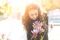 Young woman near blossoming magnolia flowers tree in spring park on sunny day. Beautiful happy girl enjoying smell in a flowering Royalty Free Stock Photo