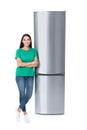 Young woman near closed refrigerator on white background Royalty Free Stock Photo