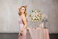 Young woman near decorated table with flowers