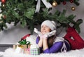 Young woman near new year tree with present