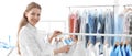 Young woman near rack with clean clothes, banner design. Dry-cleaning service Royalty Free Stock Photo