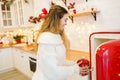 Young woman near red fridge in christmas decorated kitchen Royalty Free Stock Photo