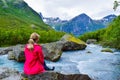 The young woman near the river which is located near path to the Briksdalsbreen Briksdal glacier. Norway Royalty Free Stock Photo