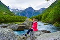 The young woman near the river which is located near path to the Briksdalsbreen Briksdal glacier. Norway Royalty Free Stock Photo