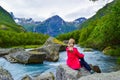 The young woman near the river which is located near path to the Briksdalsbreen Briksdal glacier. Norway Royalty Free Stock Photo