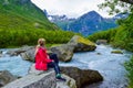 The young woman near the river which is located near path to the Briksdalsbreen Briksdal glacier. Norway Royalty Free Stock Photo