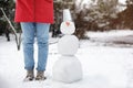 Young woman near snowman outdoors on winter day, closeup. Space for text Royalty Free Stock Photo