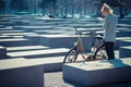 Young woman next to rented bicycles looking at the map at the holocaust memorial, Berlin, Germany