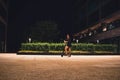 Young woman at night on a scooter in the busines center Royalty Free Stock Photo