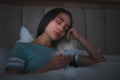 Young woman with nomophobia sleeping with smartphone in bed at night Royalty Free Stock Photo